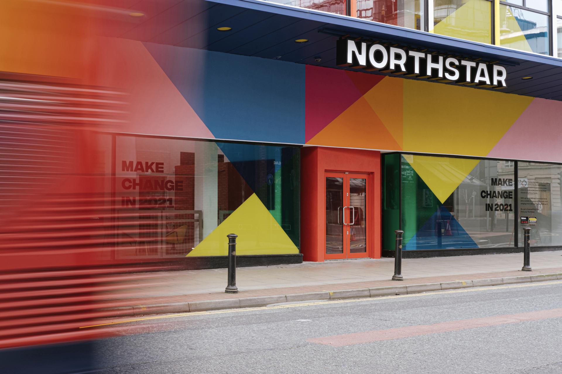 Colorful exterior of the Northstar venue in Manchester, featuring geometric designs and a message promoting community change.