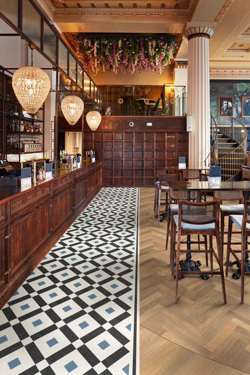 Heritage-inspired Victorian and Regency tile flooring showcased in a stylish bar with elegant decor and seating.