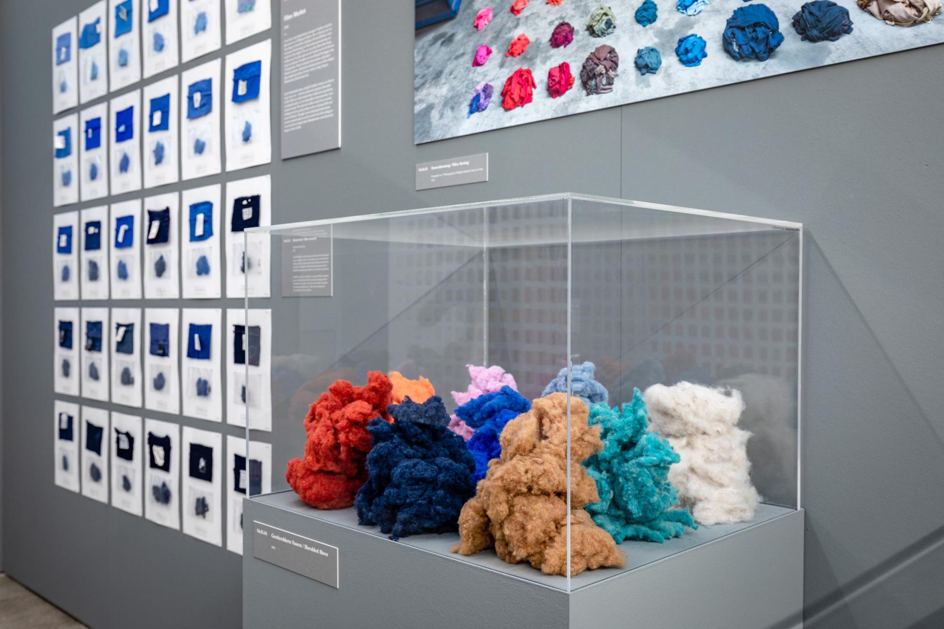 Colorful textile samples displayed in a glass case at the Vitra Design Museum, showcasing Christien Meindertsma's innovative material use.