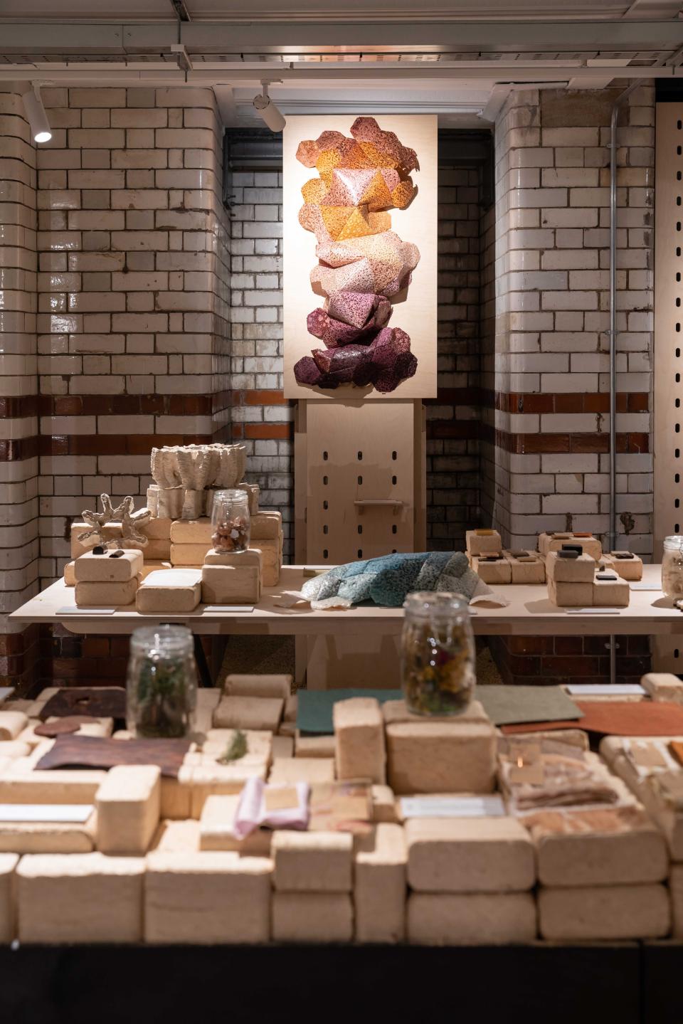 Exhibition display featuring biomaterials, showcasing colorful sculptures and natural product samples at Material Source Studio.