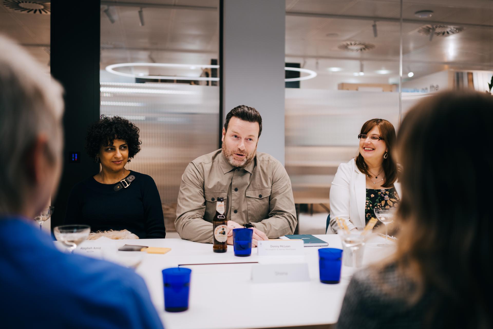 Participants engage in a roundtable discussion on neurodiversity at Material Source Studio, emphasizing flexibility and inclusivity.