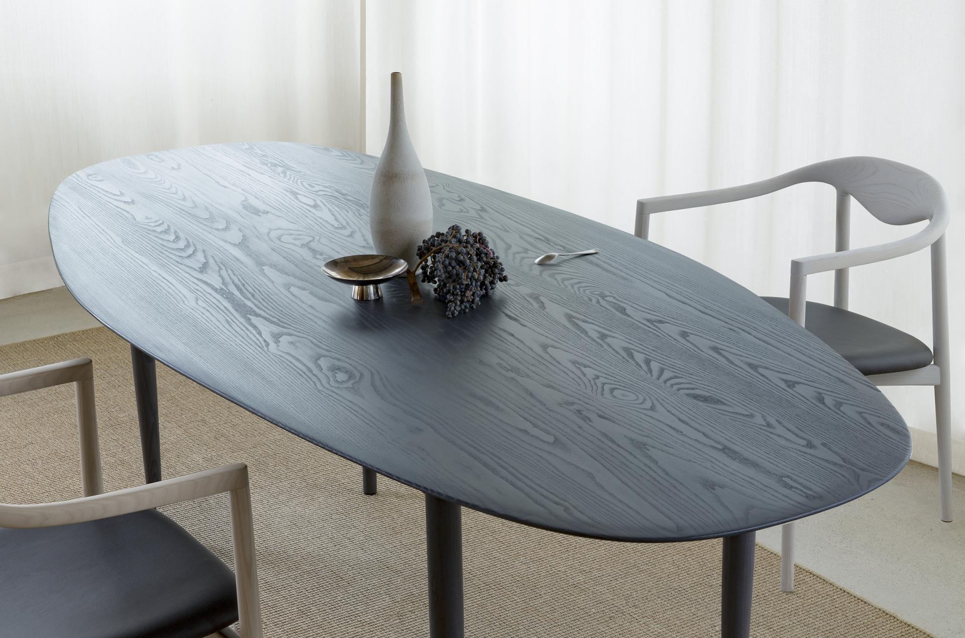 Elegant oval dining table from Brdr. Krüger's JARI collection, showcasing a sleek finish with minimalist decor elements.