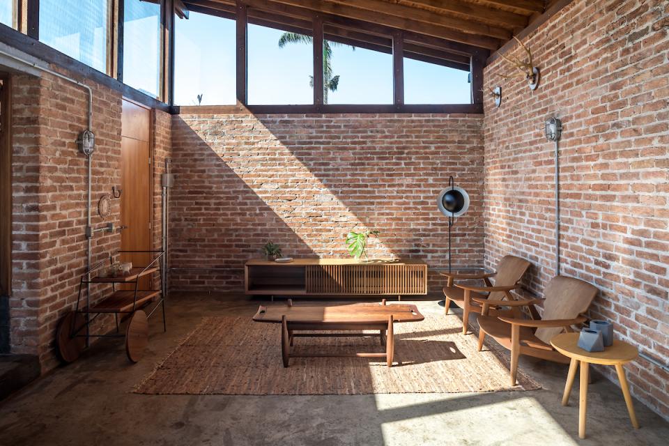 Cozy interior of The Lake House in Brazil, featuring natural materials, rustic brick walls, and stylish wooden furniture.