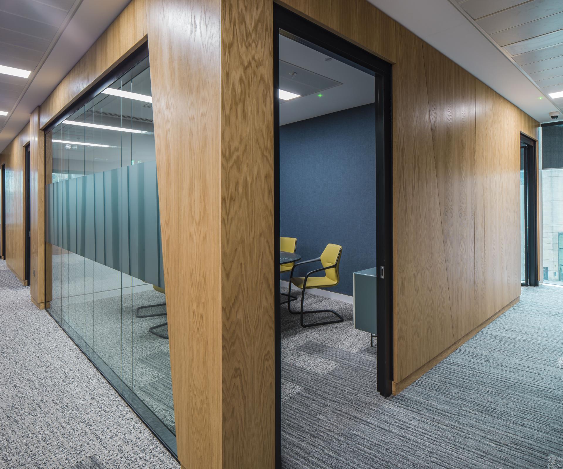 Modern office space featuring glass partitions and stylish furnishings, showcasing the design of Scotland's first WELL certified office.