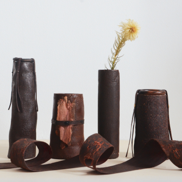 Unique biomaterial vases made from sustainable materials, showcasing innovative design and organic shapes with dried flowers.
