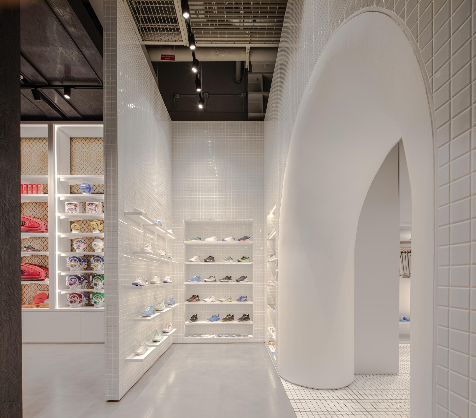 Brightly lit interior of a trendy Dubai concept store showcasing vibrant athletic shoes and activewear on minimalist displays.