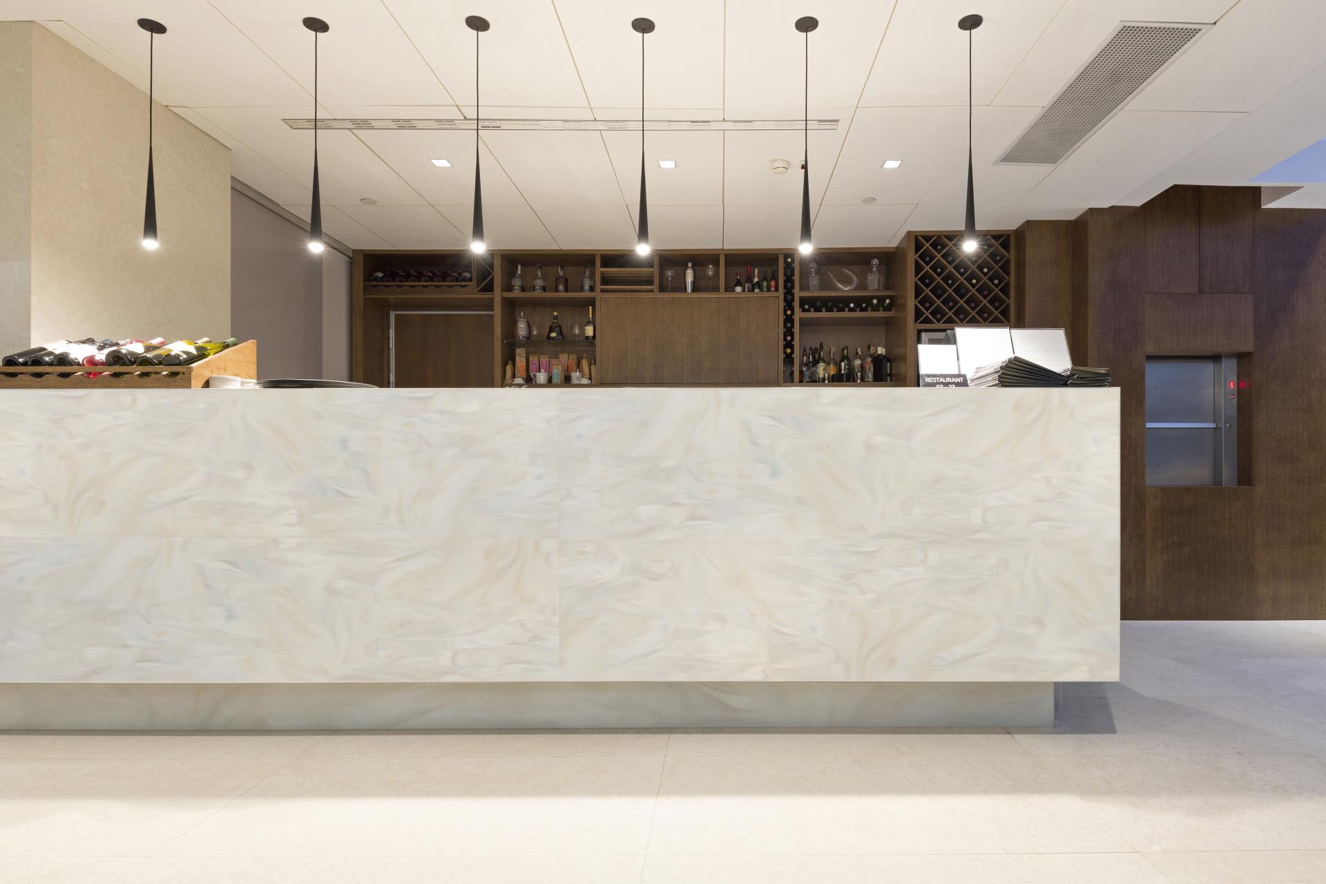 Modern reception area featuring the new Corian color range, showcasing a sleek countertop and stylish pendant lighting.
