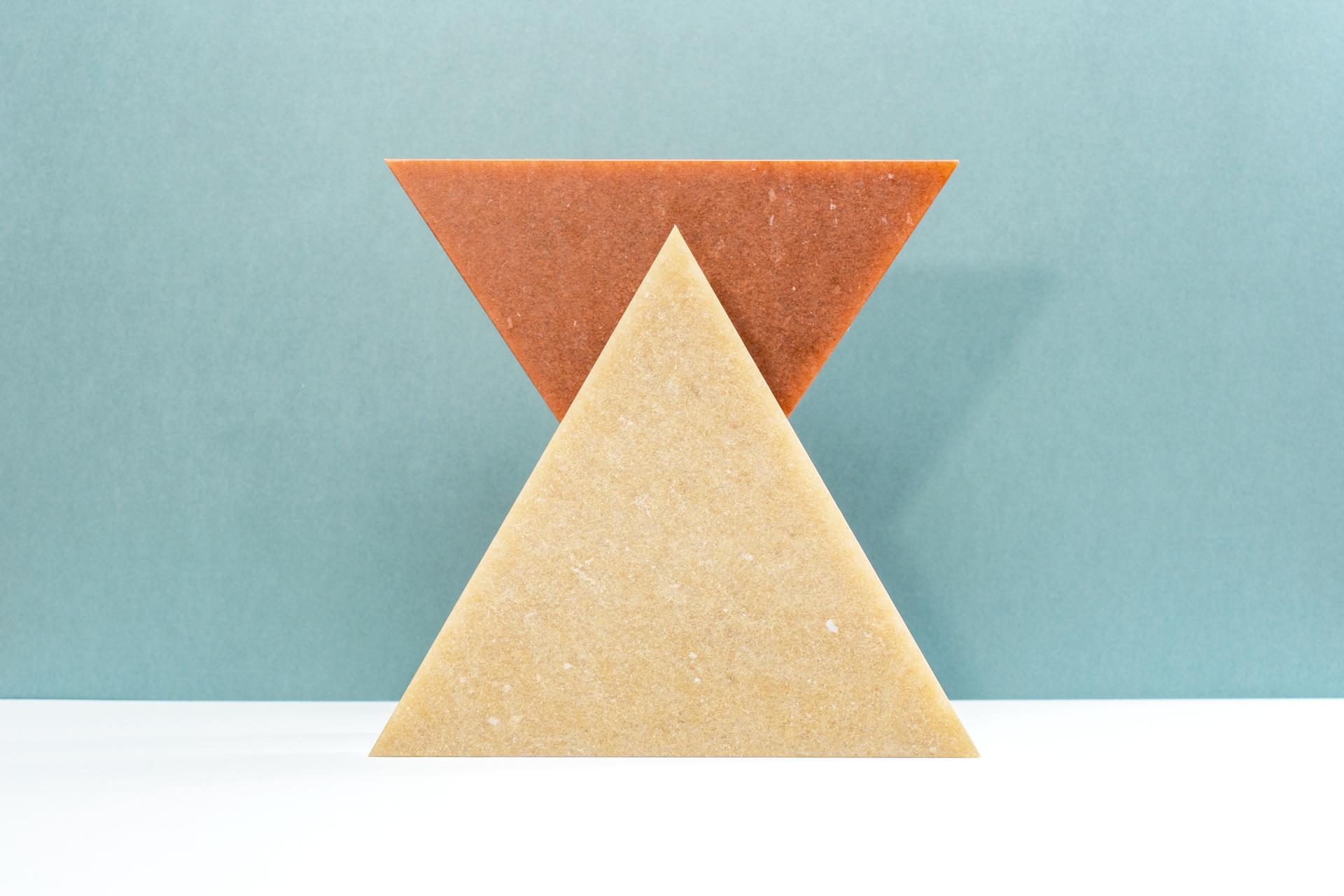 Triangular pieces of eco-friendly materials in earthy tones, representing Smile Plastics’ new Earth Collection inspired by the Welsh landscape.