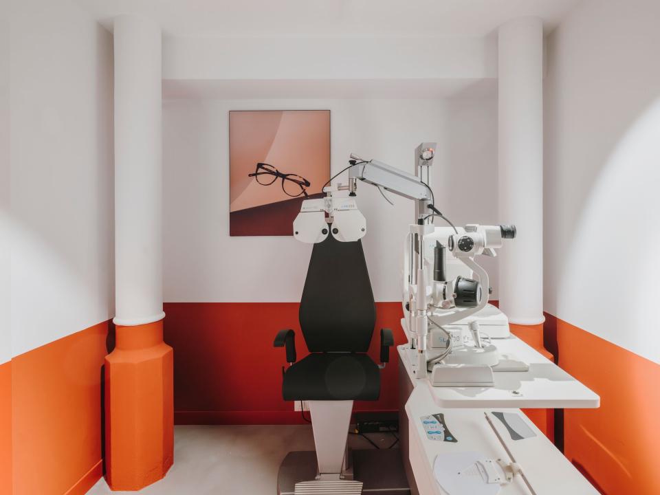 Modern eye examination room featuring stylish decor, advanced equipment, and a vibrant color scheme at ACE & TATE Barcelona.