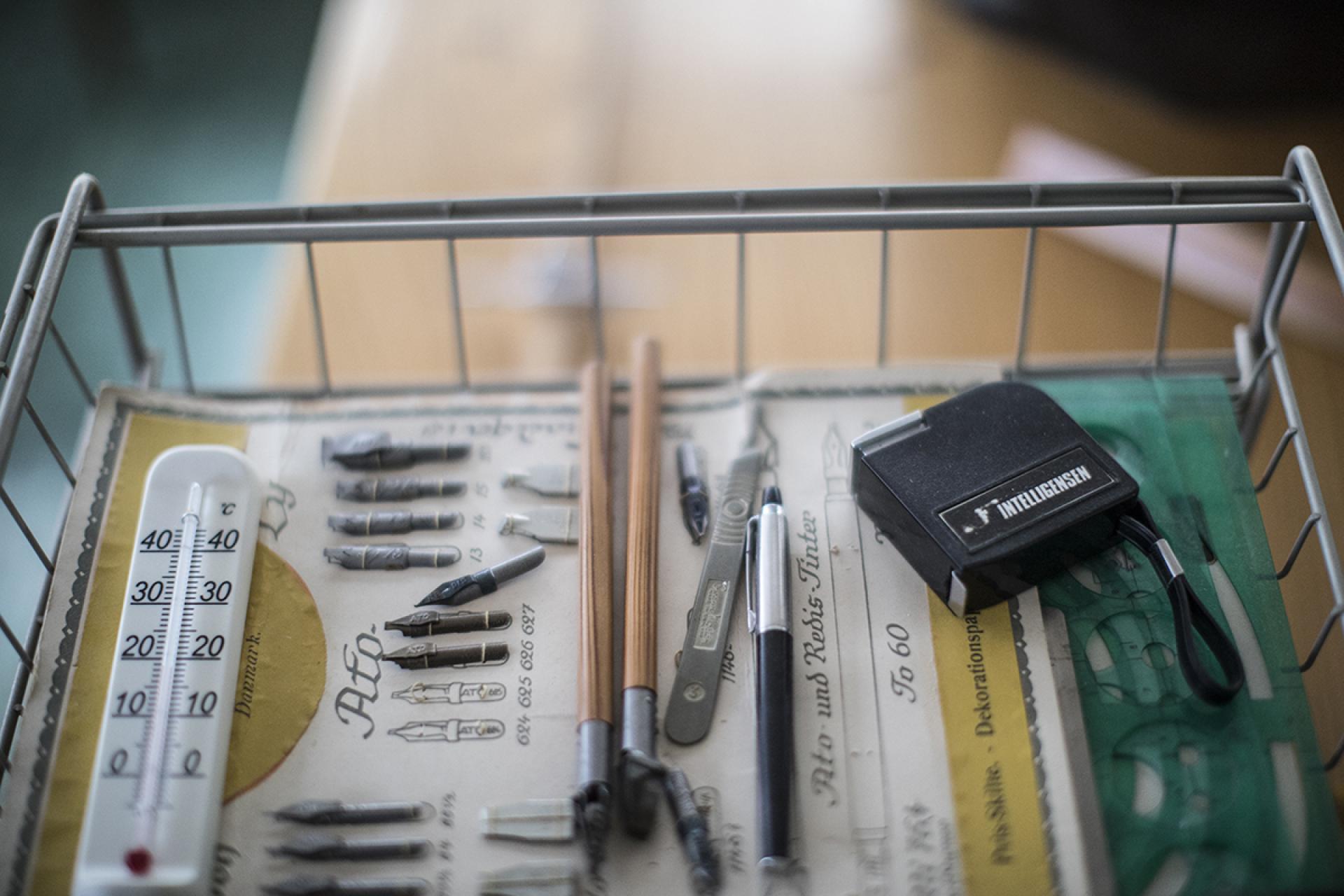 Vintage drafting tools, including pens and a thermometer, displayed in a basket in Karin and Bruno Mathsson's preserved home.