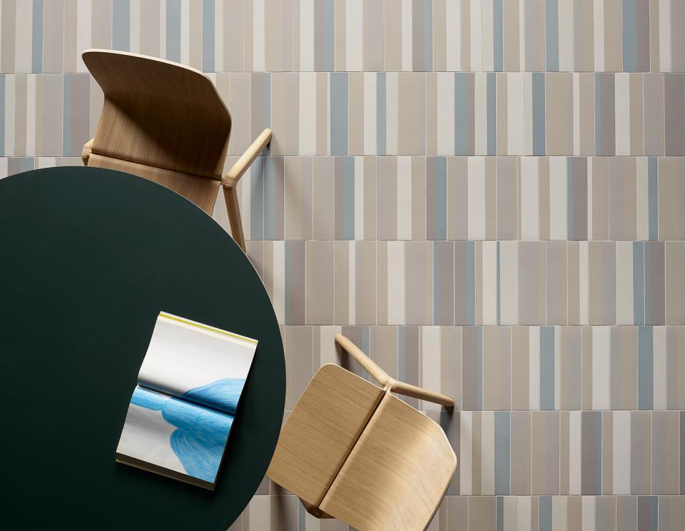 Elegant Piano tile collection by Mutina showcased in a modern setting with wooden chairs and an art booklet.