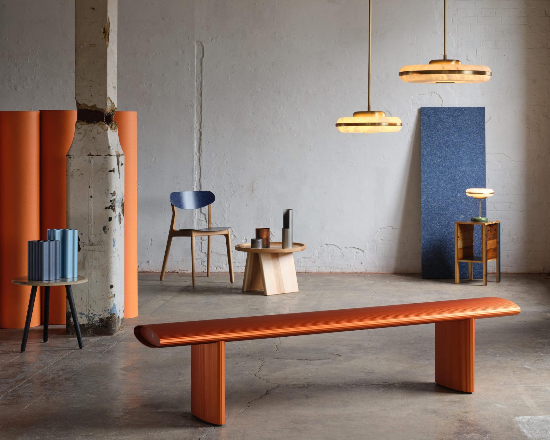 Contemporary interior featuring a vibrant orange bench, stylish furniture, and artistic lighting at Material Matters, London Design Festival 2023.