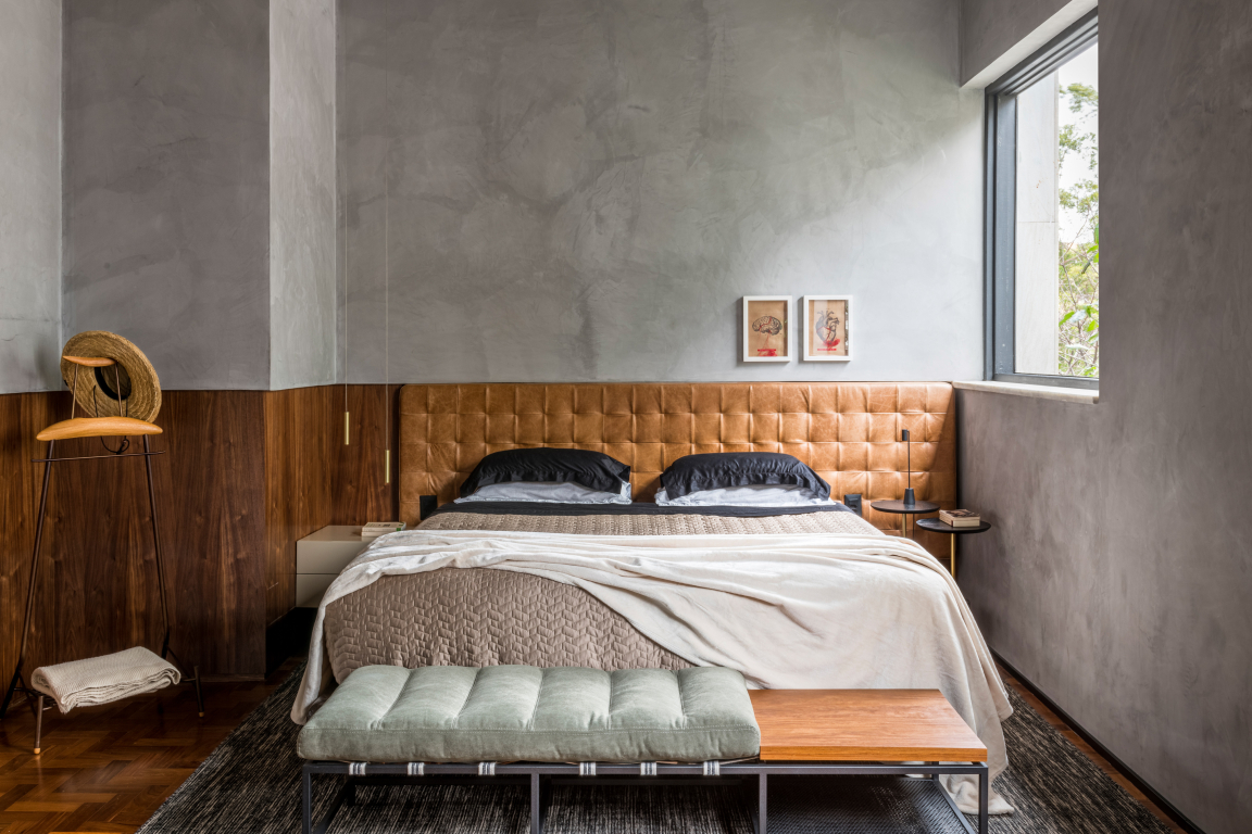A warm, inviting bedroom featuring a tufted leather headboard, natural light, and modern decor that embraces nature-inspired design.
