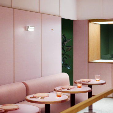 Nostalgic 1950s-style café interior featuring dusky-pink walls, circular tables, and elegant glassware.
