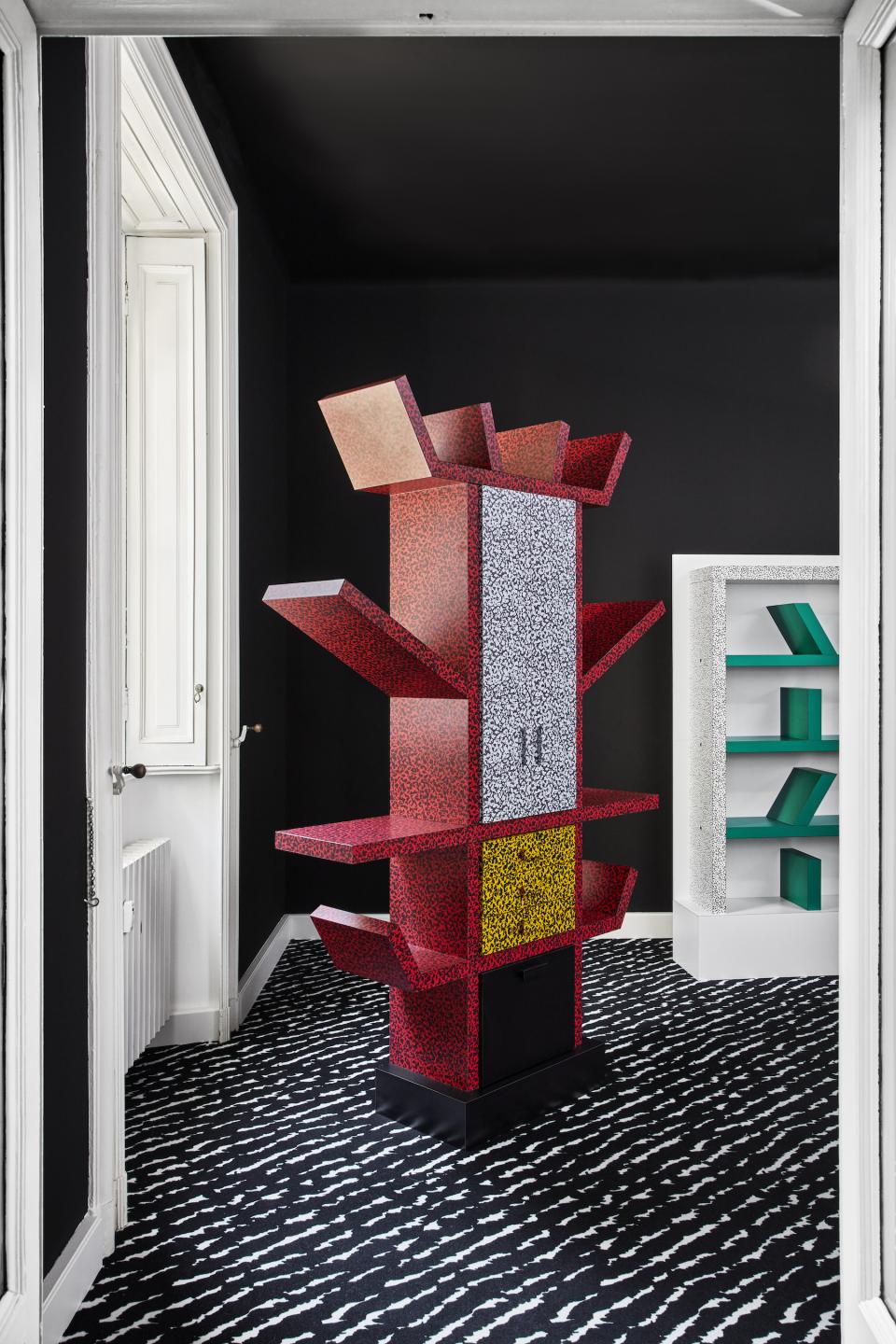 Colorful Memphis Milano shelving unit in a modern interior, showcasing bold patterns and creative design elements.
