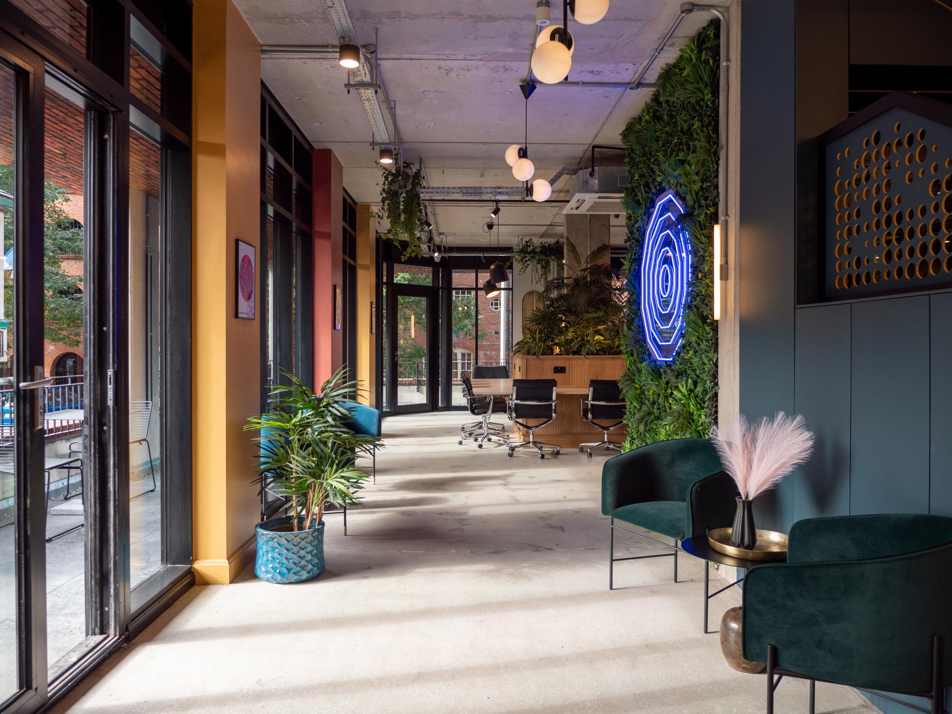 Stylish workspace at Colony CoWork featuring modern seating, greenery, and an inviting coffee corner designed by Scanomat.