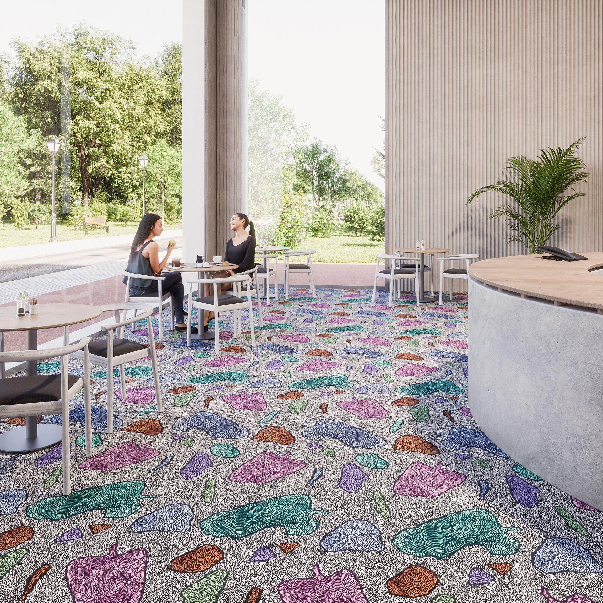 Colorful patterned flooring in a modern café setting, showcasing Forbo's JM Galeote range and vibrant interior design.