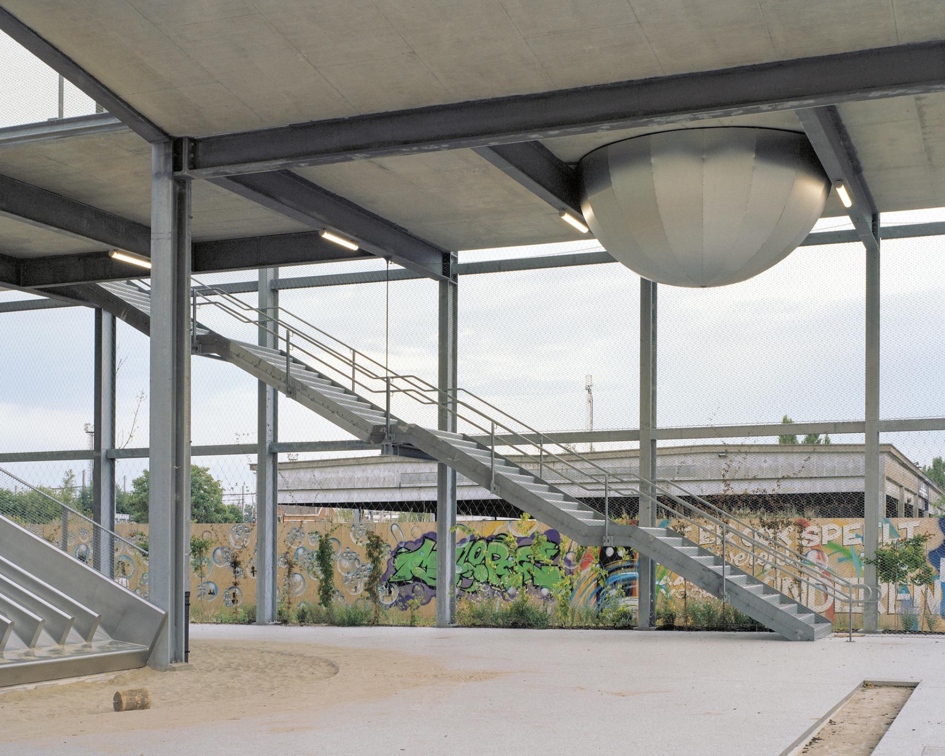 Interior view of a multipurpose school featuring a unique staircase and artistic graffiti wall in the Harbourside development.