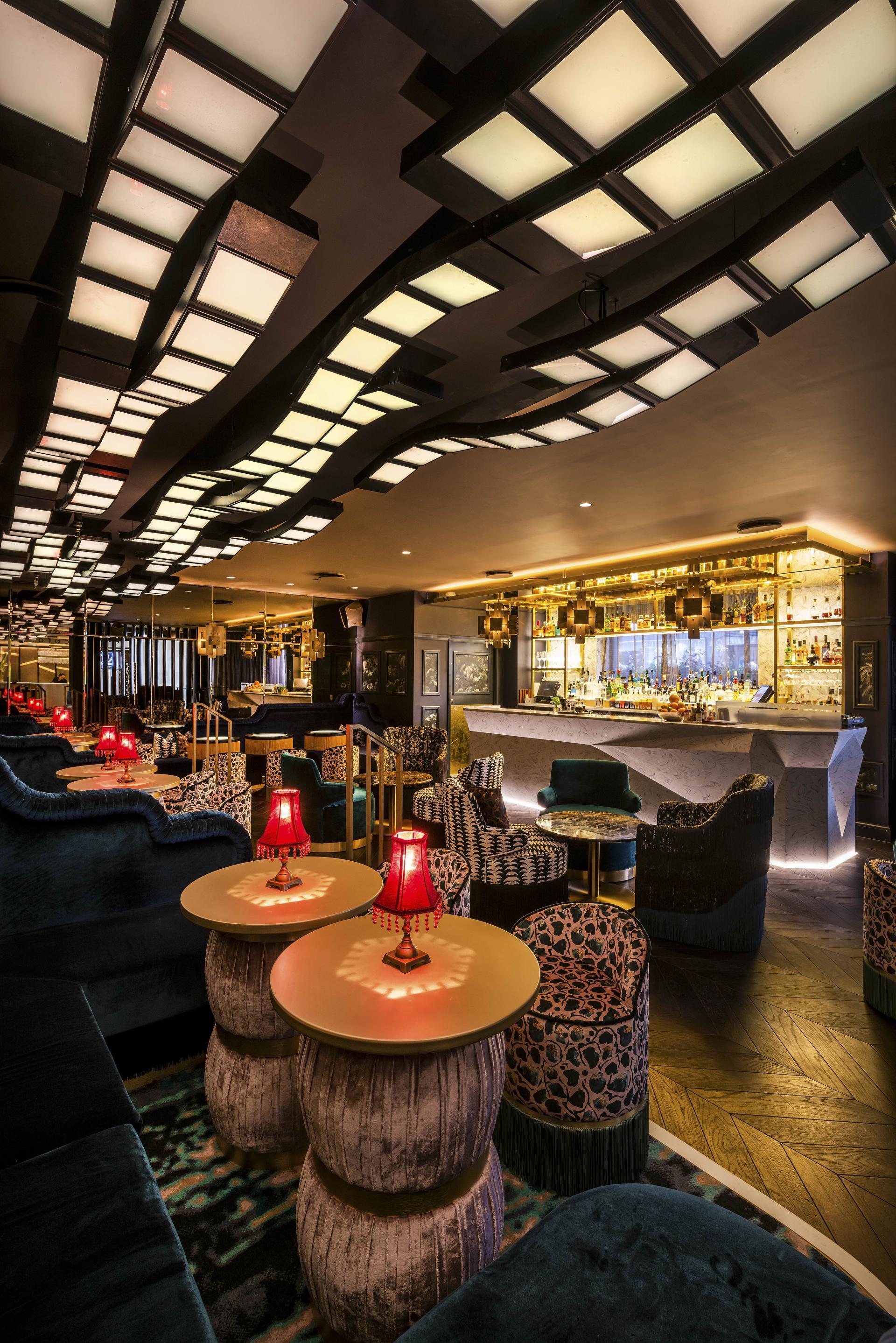 Luxurious interior of The Colony Club featuring elegant seating, stylish tables, and a vibrant bar atmosphere.