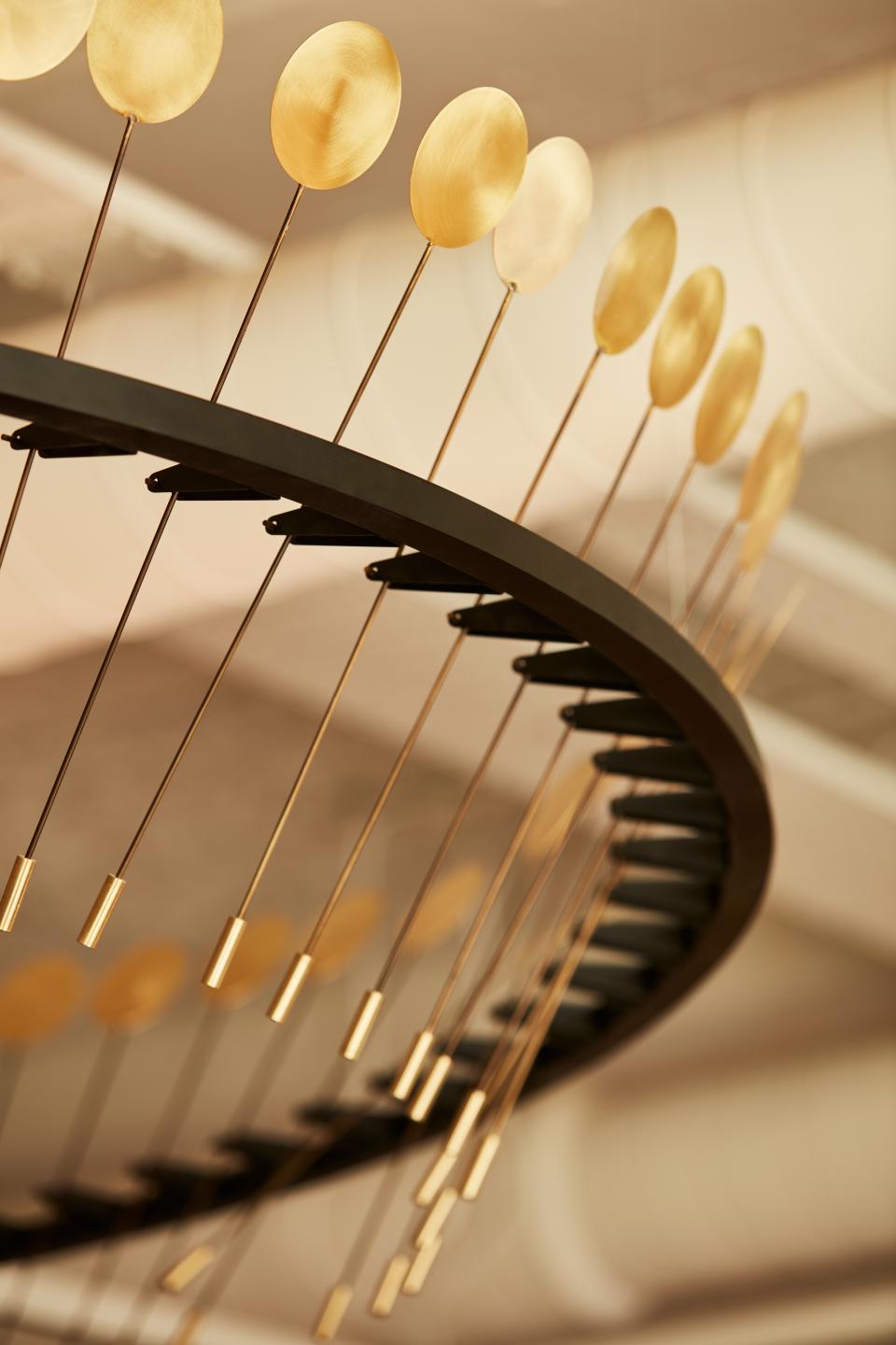 Chic chandelier with gold accents, highlighting the elegant design inspired by cocktail bars in a London co-working space.