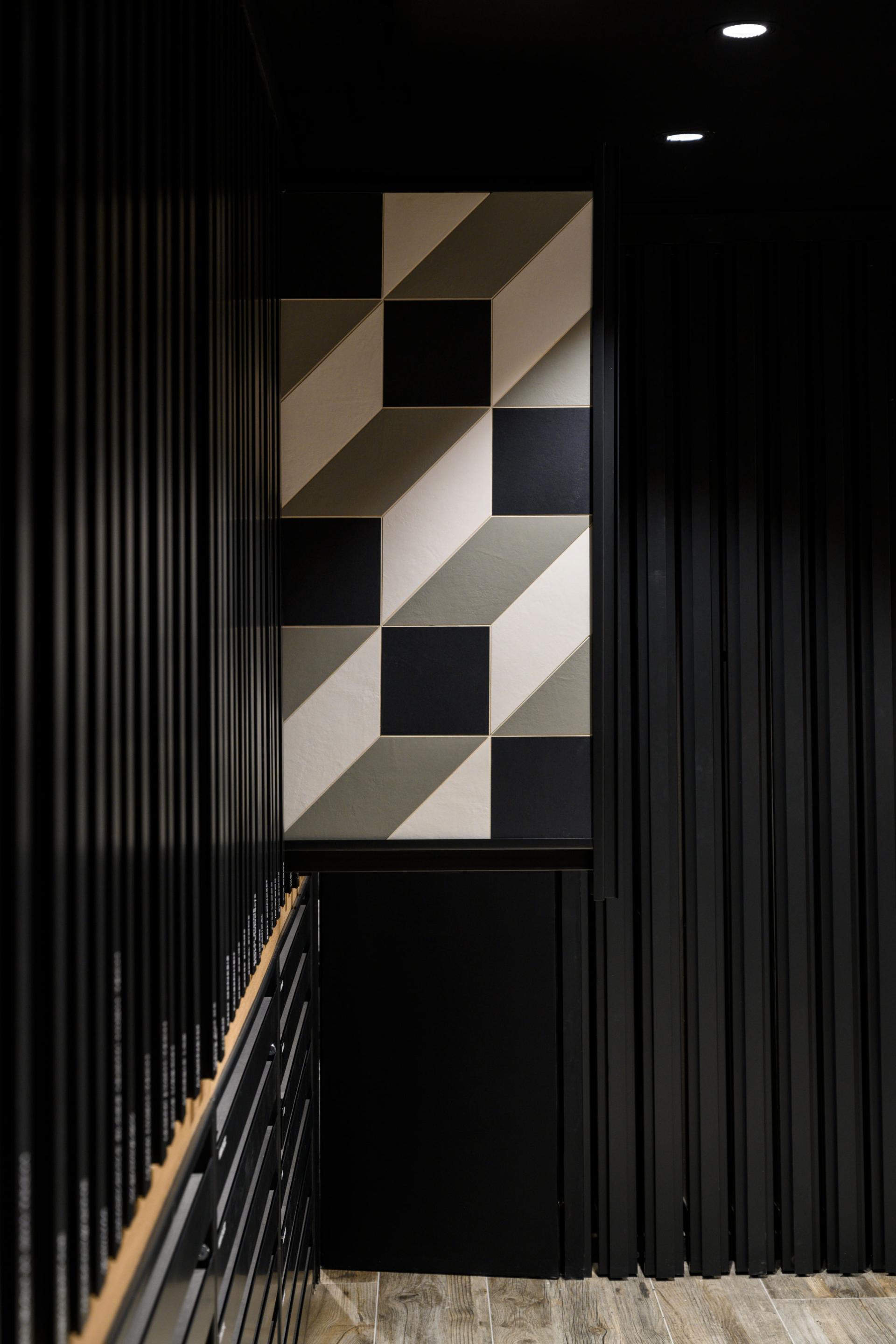 Stylish interior of Iris Ceramica Group's UK showroom featuring geometric ceramic tiles and sleek black cabinetry.