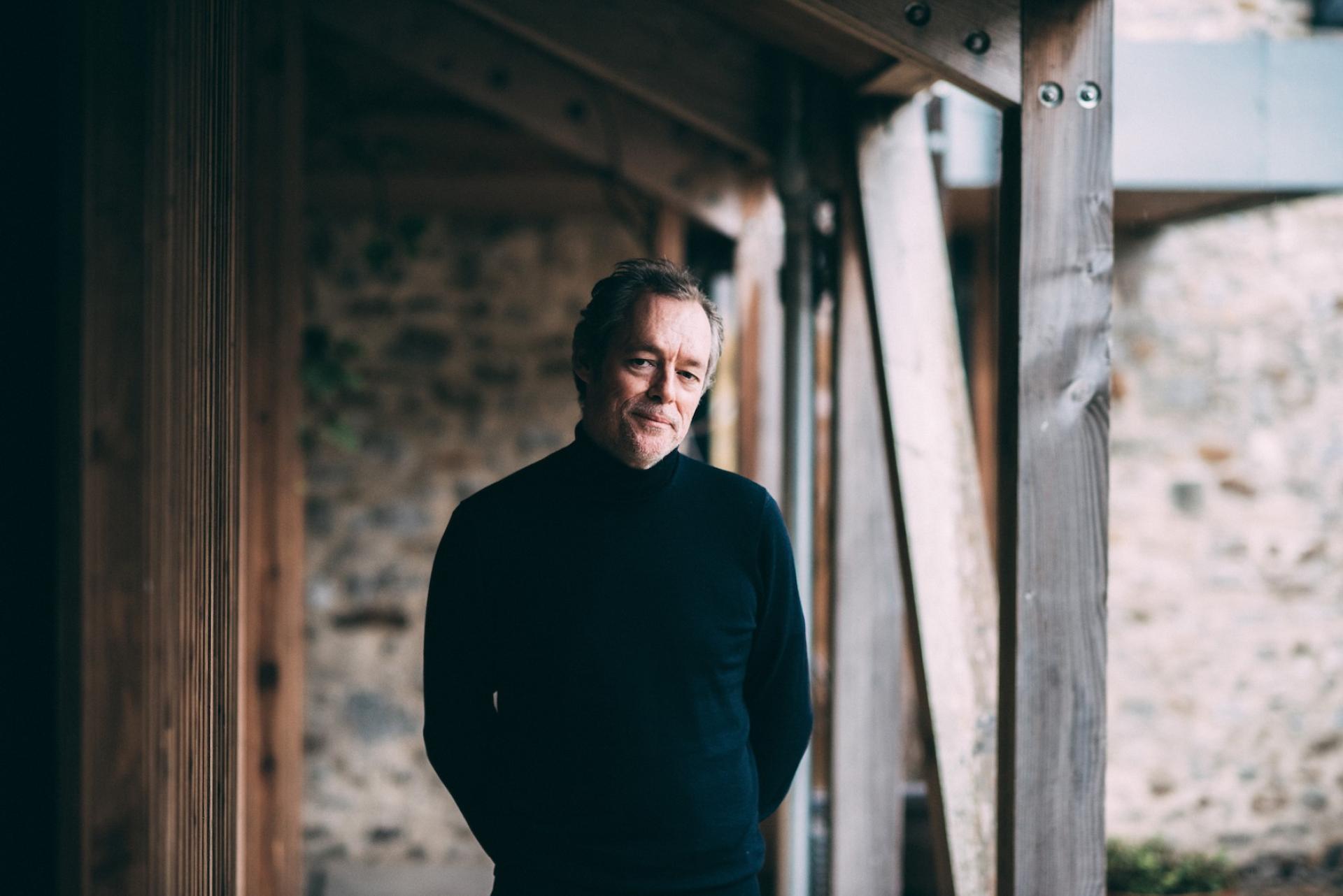 Portrait of a thoughtful man in a modern, natural setting reflecting the themes of contemporary design and sustainability.