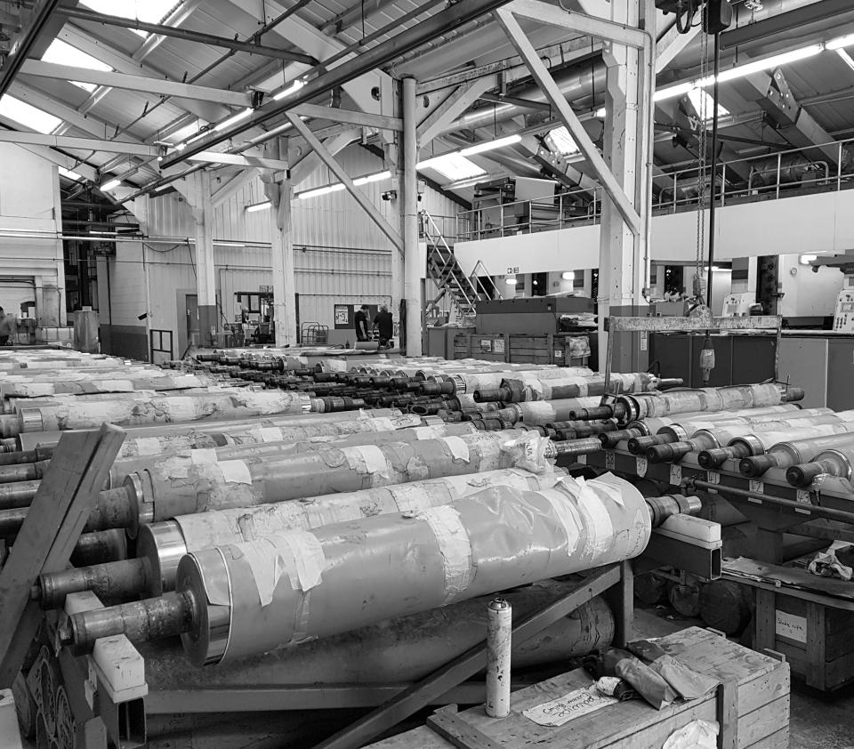 Production area at Muraspec factory, showcasing rolling machines and equipment for manufacturing wall coverings.