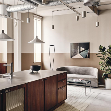 Contemporary office interior of Brock House featuring bespoke lighting, a modern kitchen, and stylish furnishings.
