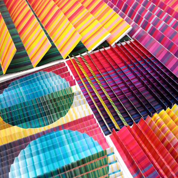 Vibrant textile patterns in shades of blue, pink, and yellow, showcasing Margo Selby's colorful design aesthetic for her installation.