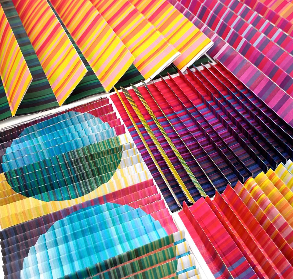 Vibrant textile patterns in shades of blue, pink, and yellow, showcasing Margo Selby's colorful design aesthetic for her installation.