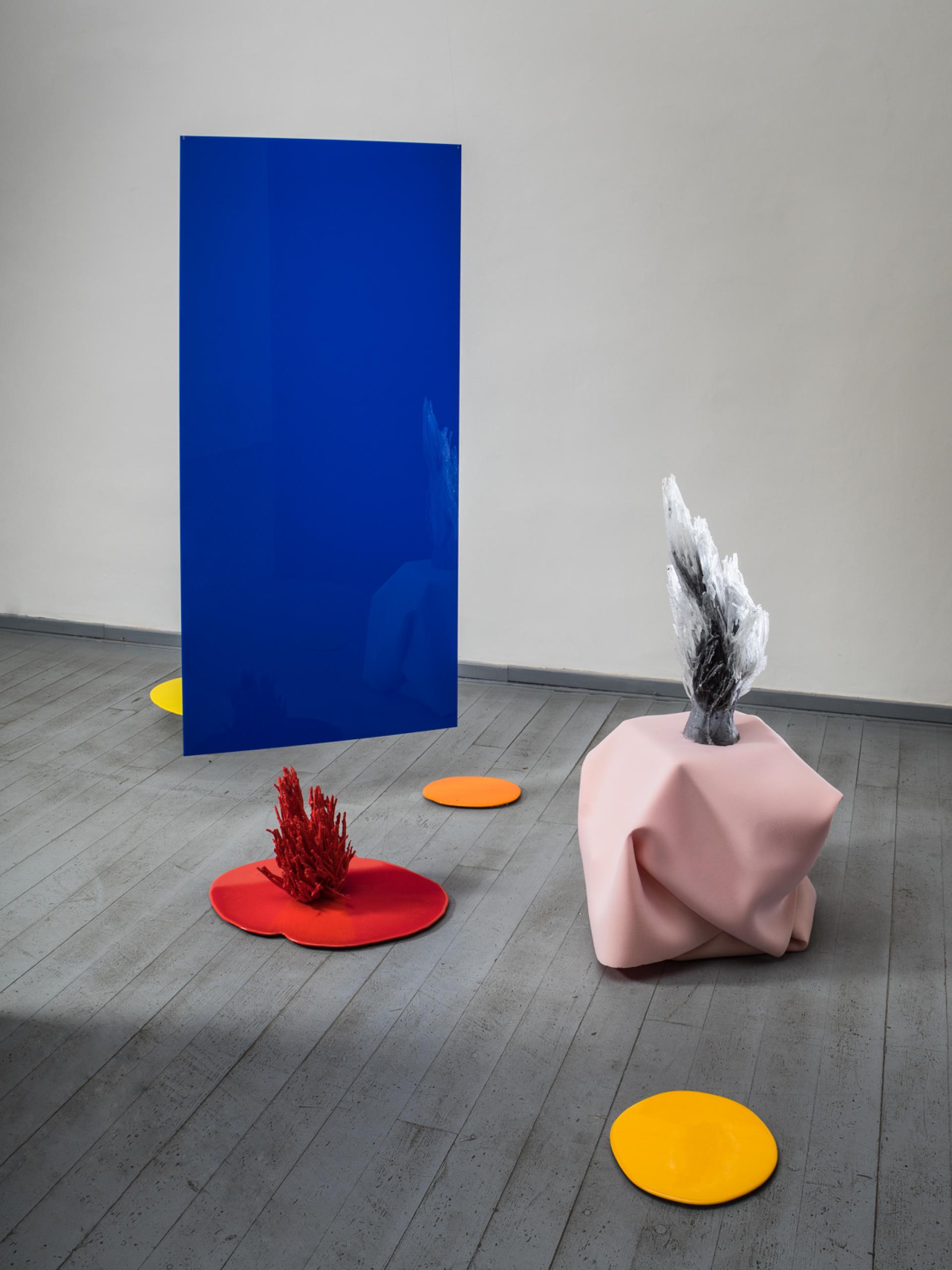 Vibrant glass installations featuring blue, red, and yellow elements, showcasing innovative design at the London Design Fair.