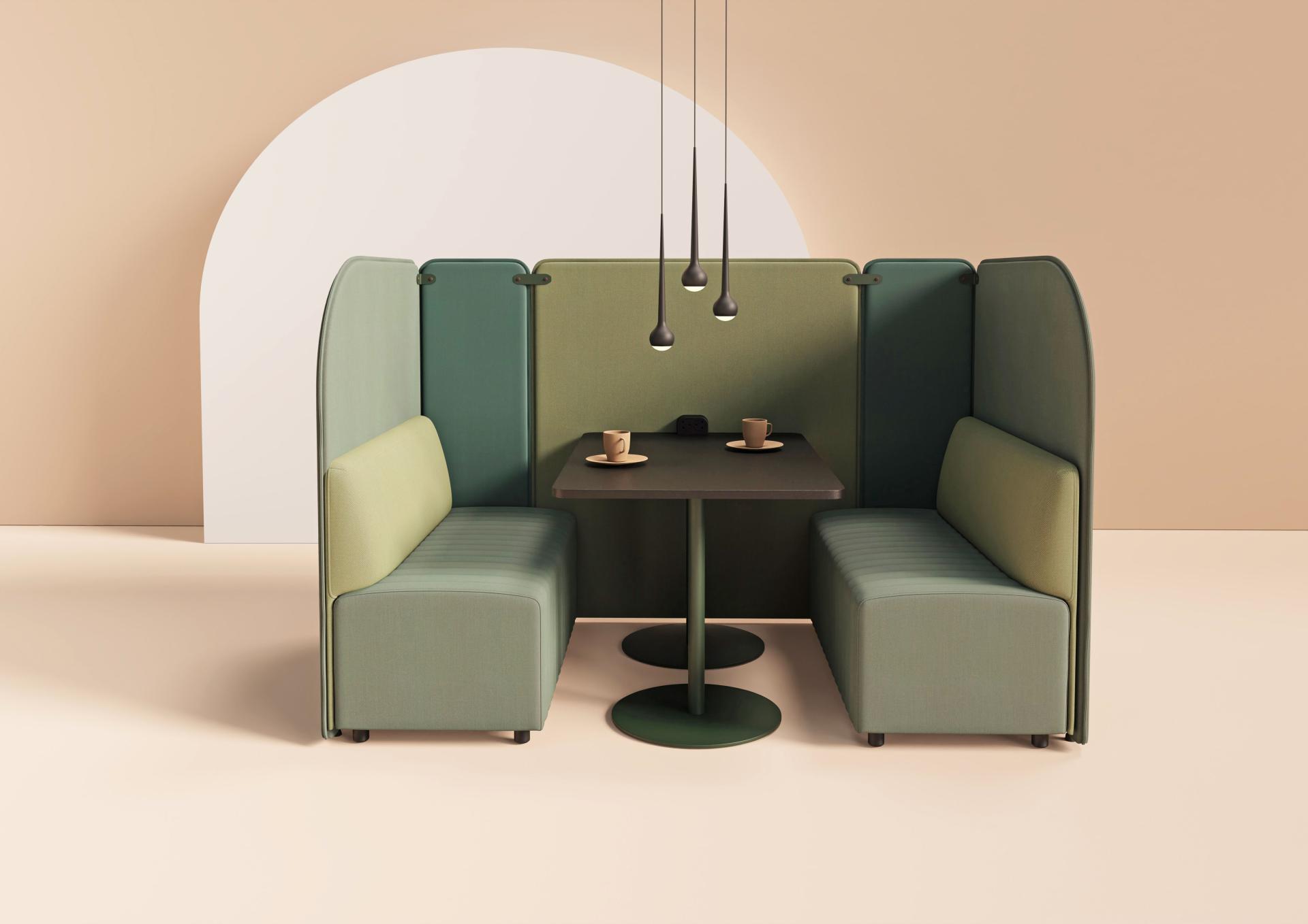 Modular seating arrangement featuring green upholstered booths and a central table, designed for modern workspace flexibility.