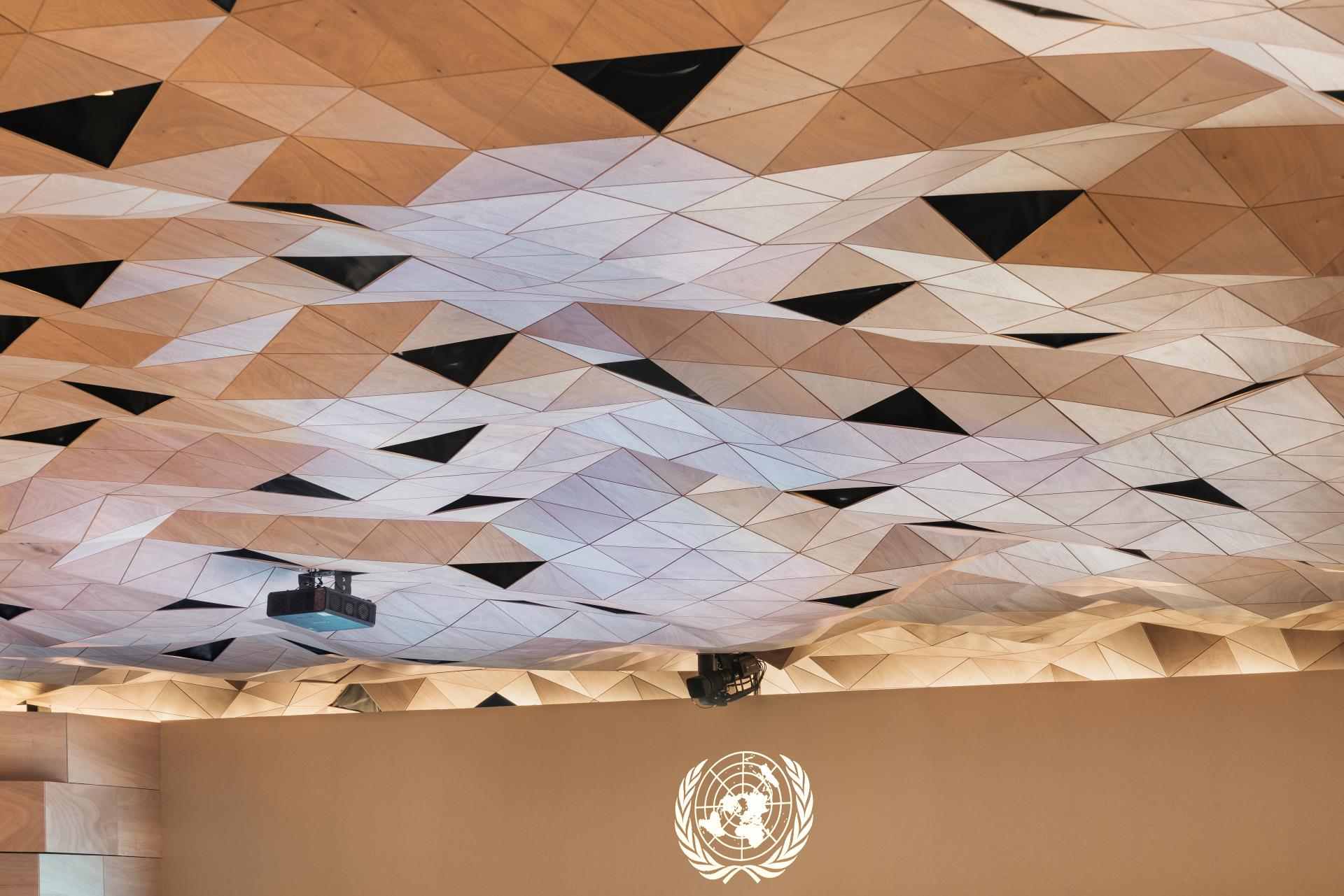 Elegant wooden ceiling design with triangular shapes in the Assembly Hall of the United Nations Palace in Geneva.
