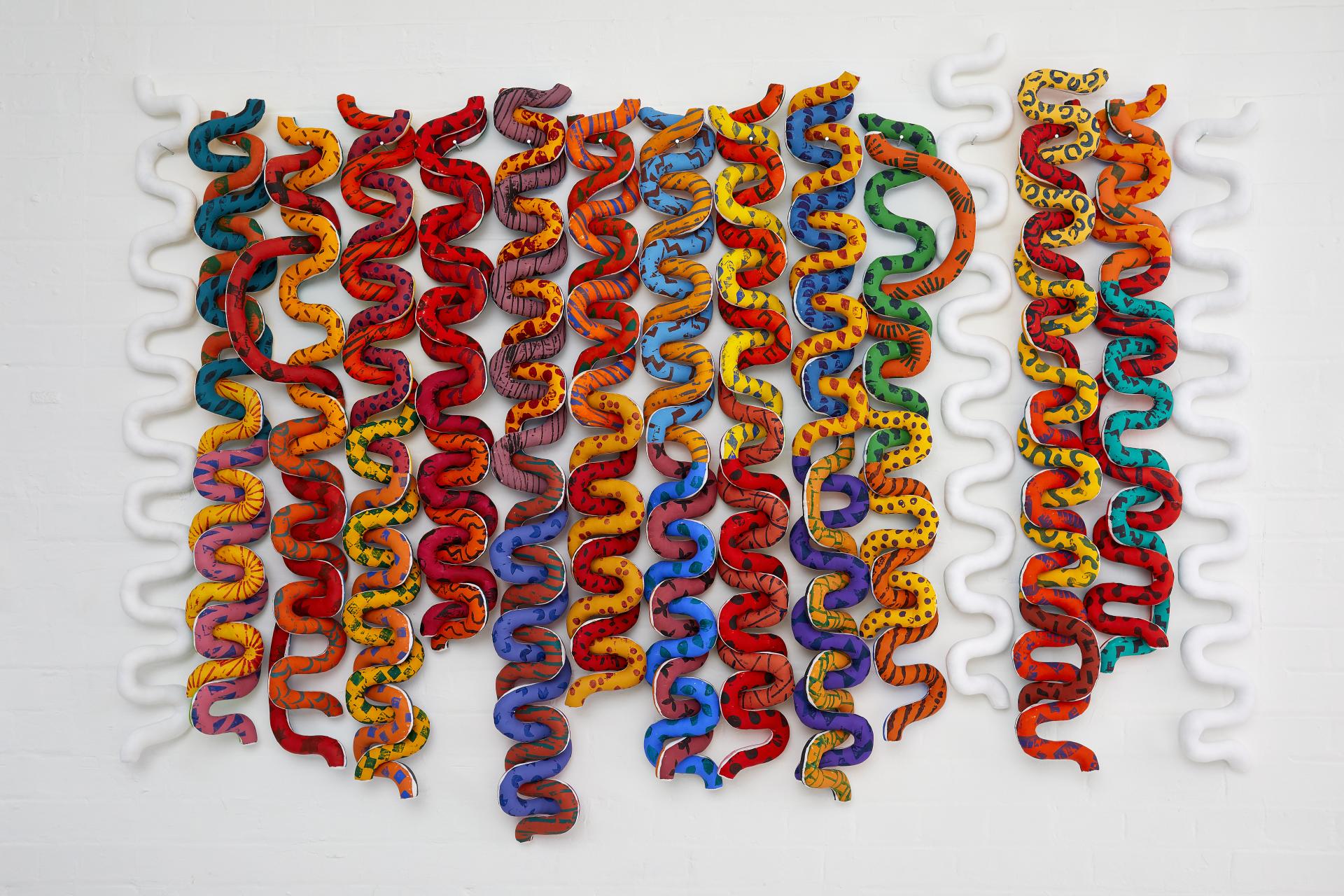 Colorful textile art installation by British artist Anna Ray, showcasing intricate patterns inspired by London's weaving history.