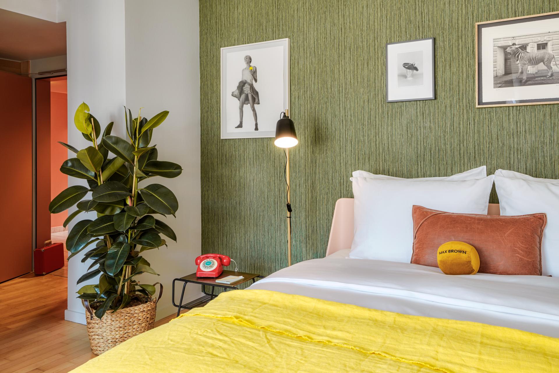 Stylish hotel room in Max Brown 7th District, featuring vibrant decor, cozy bedding, and artistic wall art in Vienna.