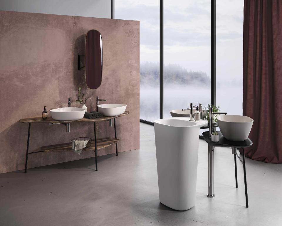 Modern bathroom featuring VitrA's Plural collection, showcasing elegant sinks and a freestanding tub against a stylish backdrop.