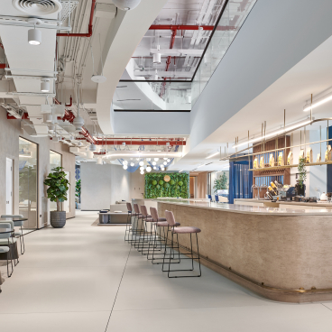 Modern co-working space at Sharjah Entrepreneurship Center featuring stylish seating, a bar, and greenery for a creative atmosphere.