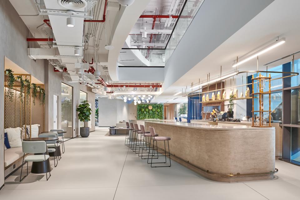 Modern co-working space at Sharjah Entrepreneurship Center featuring stylish seating, a bar, and greenery for a creative atmosphere.