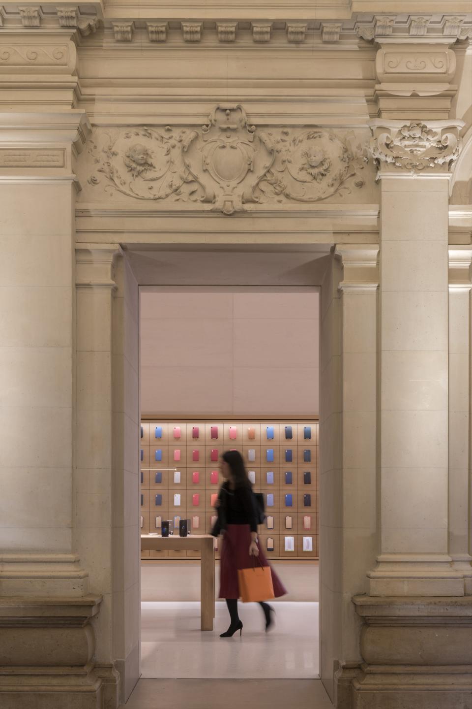 Visitors experience the elegant Apple Store design featuring vintage architecture and modern product displays in Paris.
