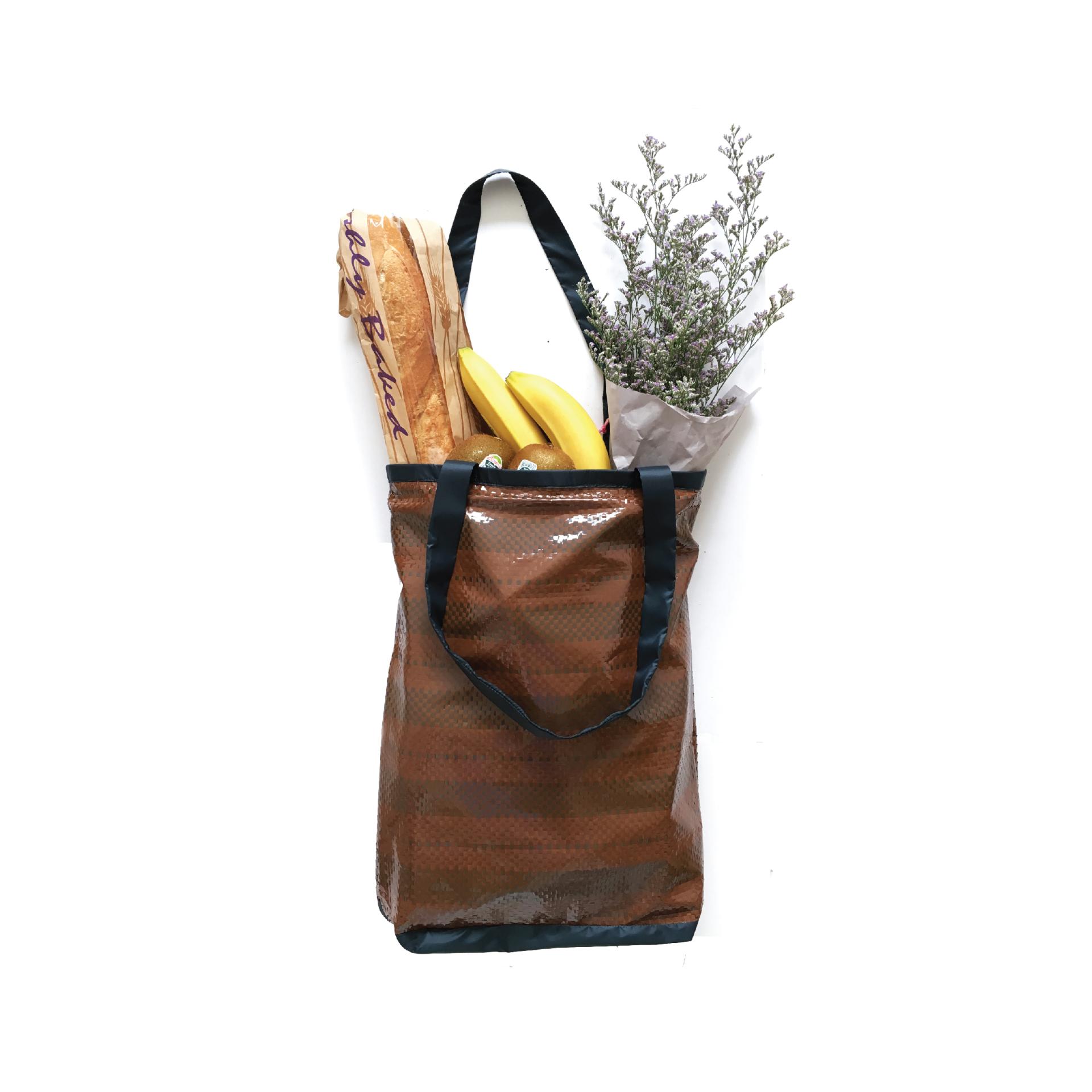 Eco-friendly tote bag filled with a baguette, bananas, and fresh herbs, representing sustainable living and up-cycling initiatives.