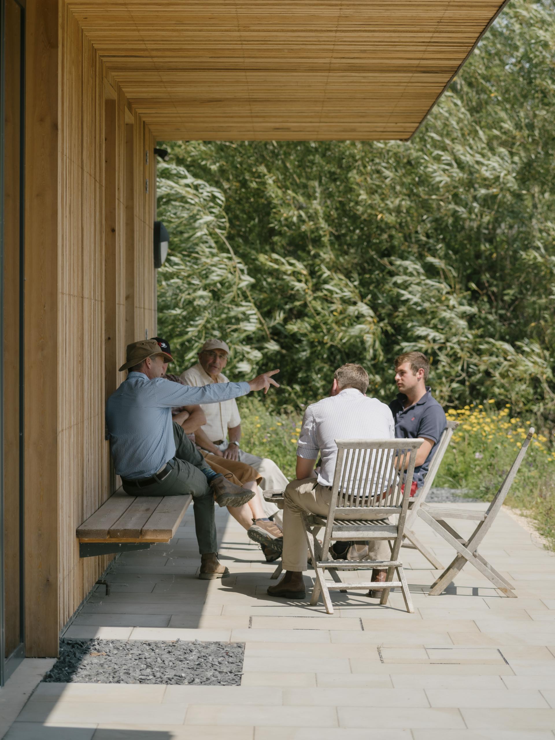 Group discussion outside a sustainable farming education centre, highlighting collaboration and knowledge sharing in regenerative agriculture.