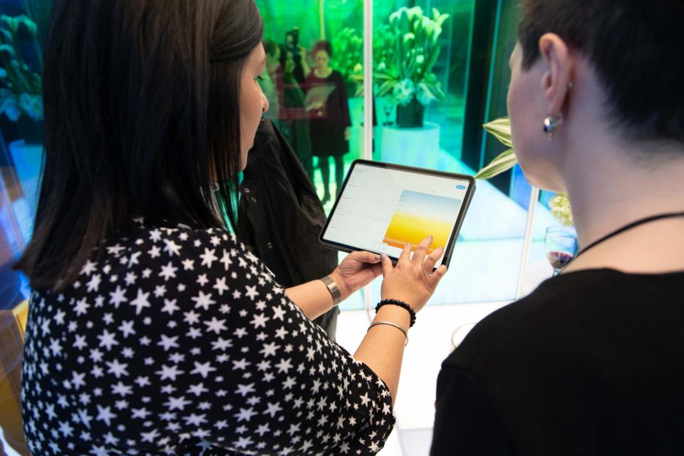 Participants engage with Lutron's Prismatic experience, using digital tools to explore interactive lighting design concepts.