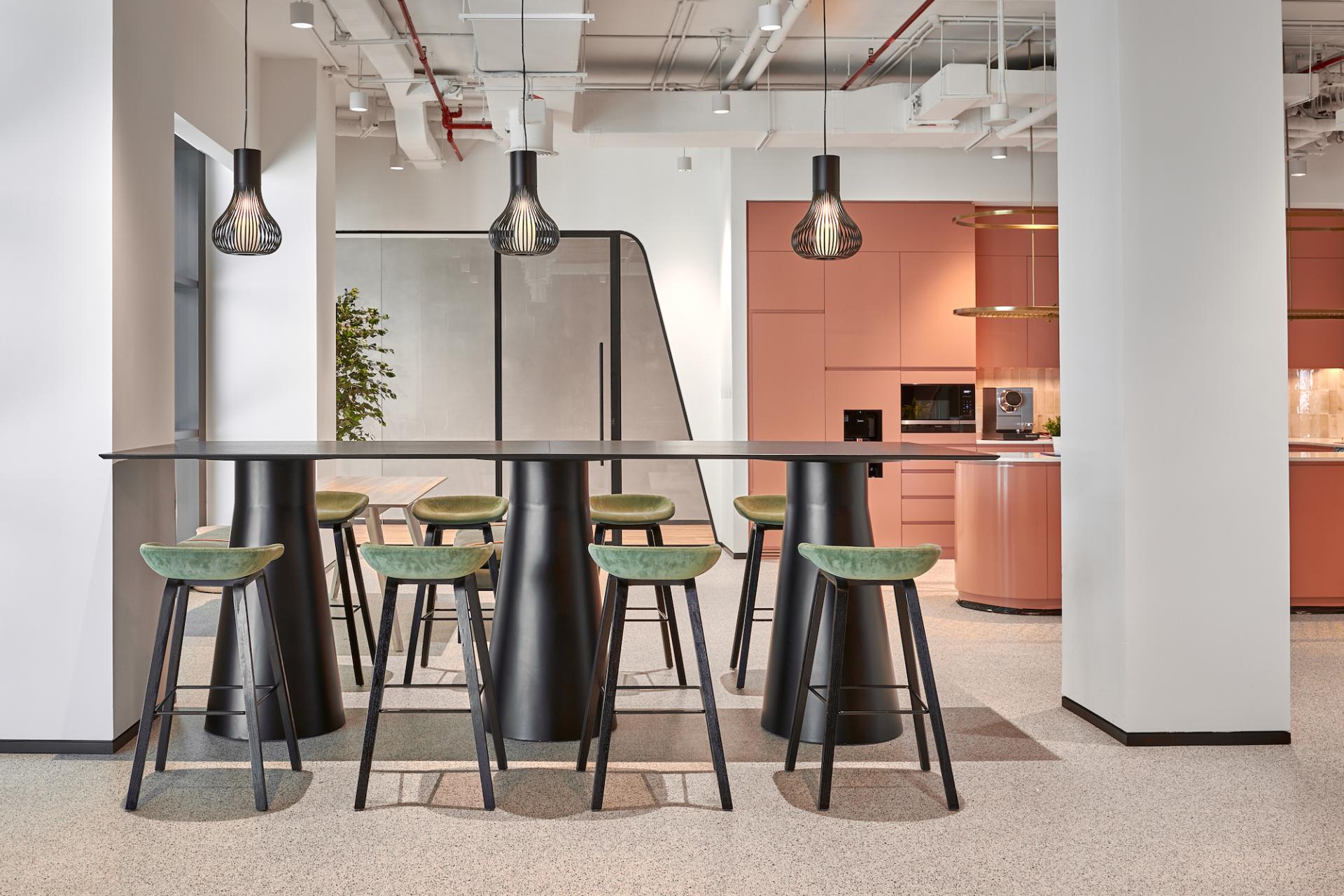 Modern workspace featuring stylish black bar stools and a sleek table, designed for collaboration in an entrepreneurship center.