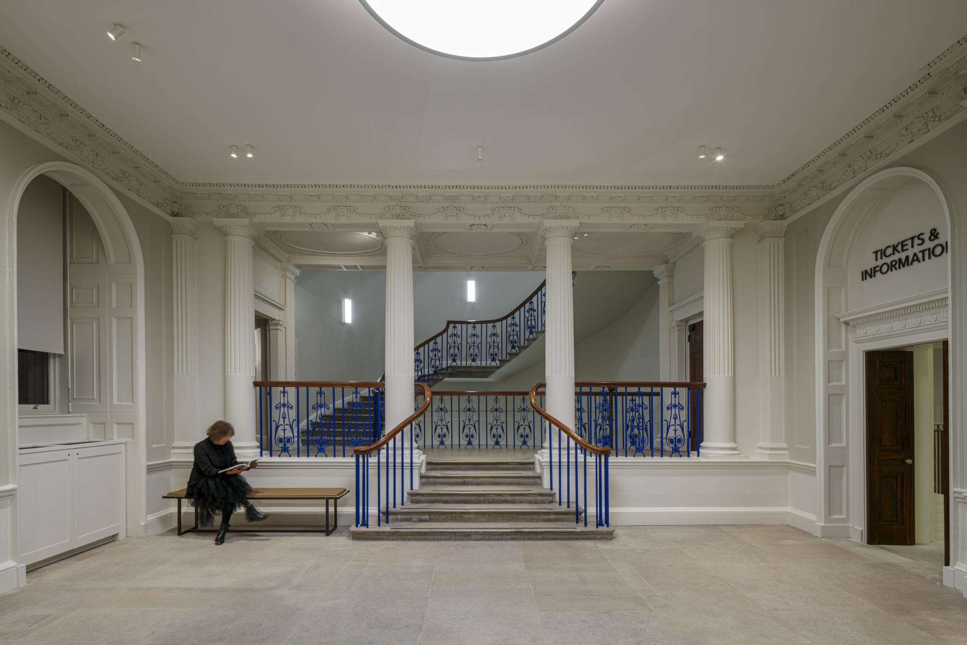 Modern entryway of The Courtauld Gallery, showcasing elegant architecture and a visitor seating area.