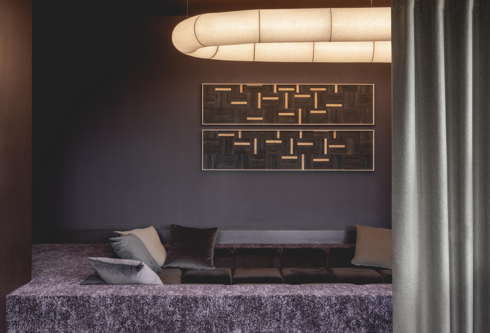 Modern interior featuring plush seating, patterned artwork, and soft lighting, reflecting harmonious architecture and design principles in Liverpool.