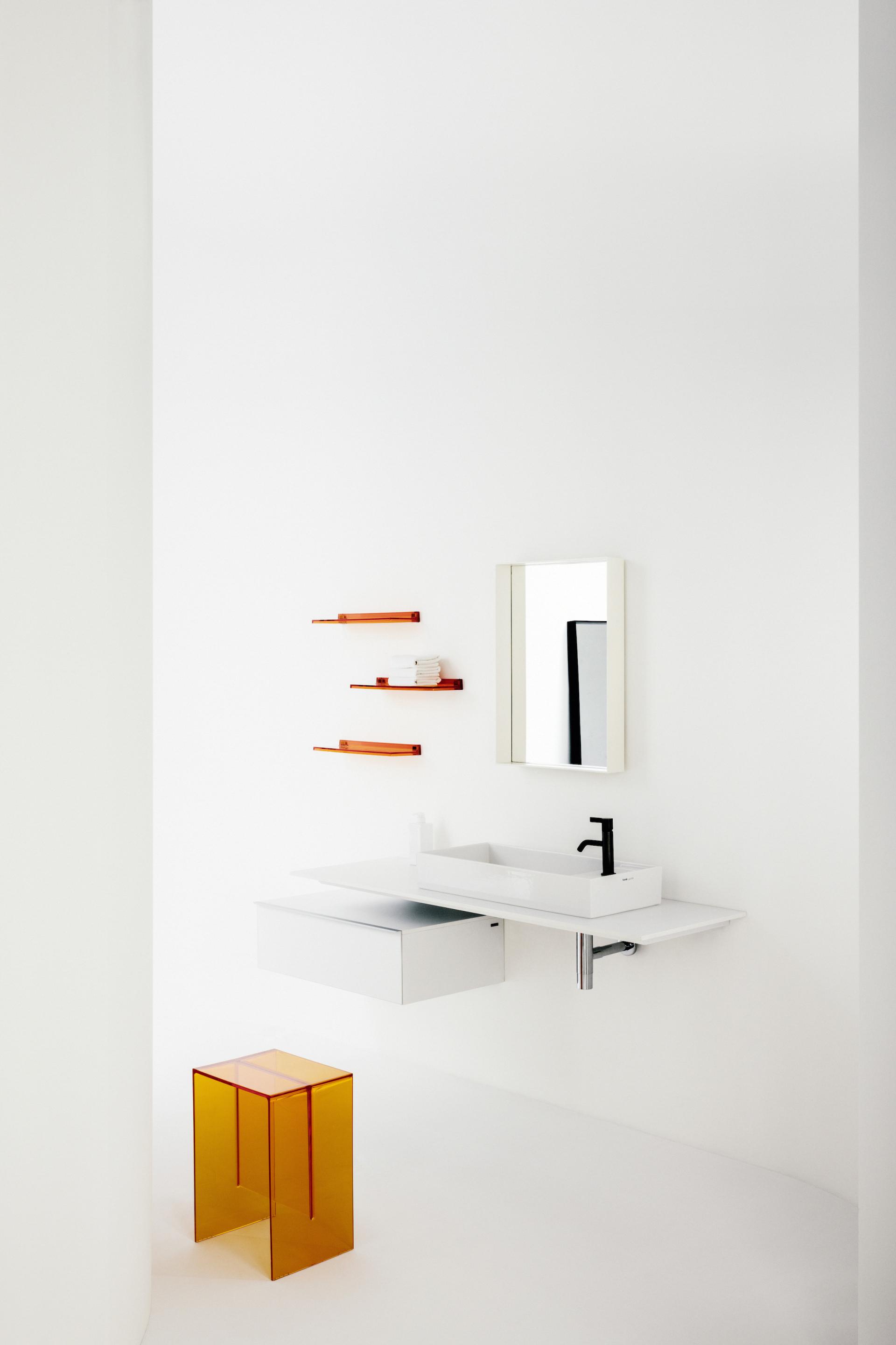 Modern bathroom design showcasing sleek white fixtures, a minimalist vanity, colorful shelves, and an industrial-style transparent stool.