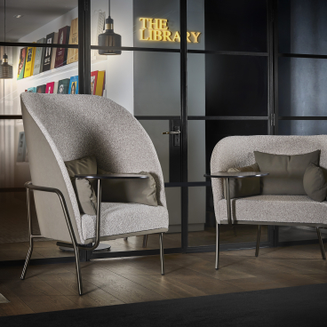 Modern Tiros seating collection by Gresham, featuring stylish armchairs with plush cushions in a sophisticated library setting.