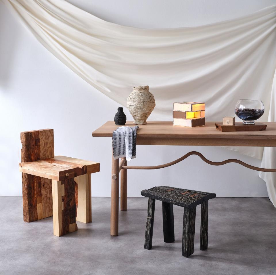 Sustainable wooden chair and stools displayed alongside natural decor elements on a stylish wooden table in a serene setting.