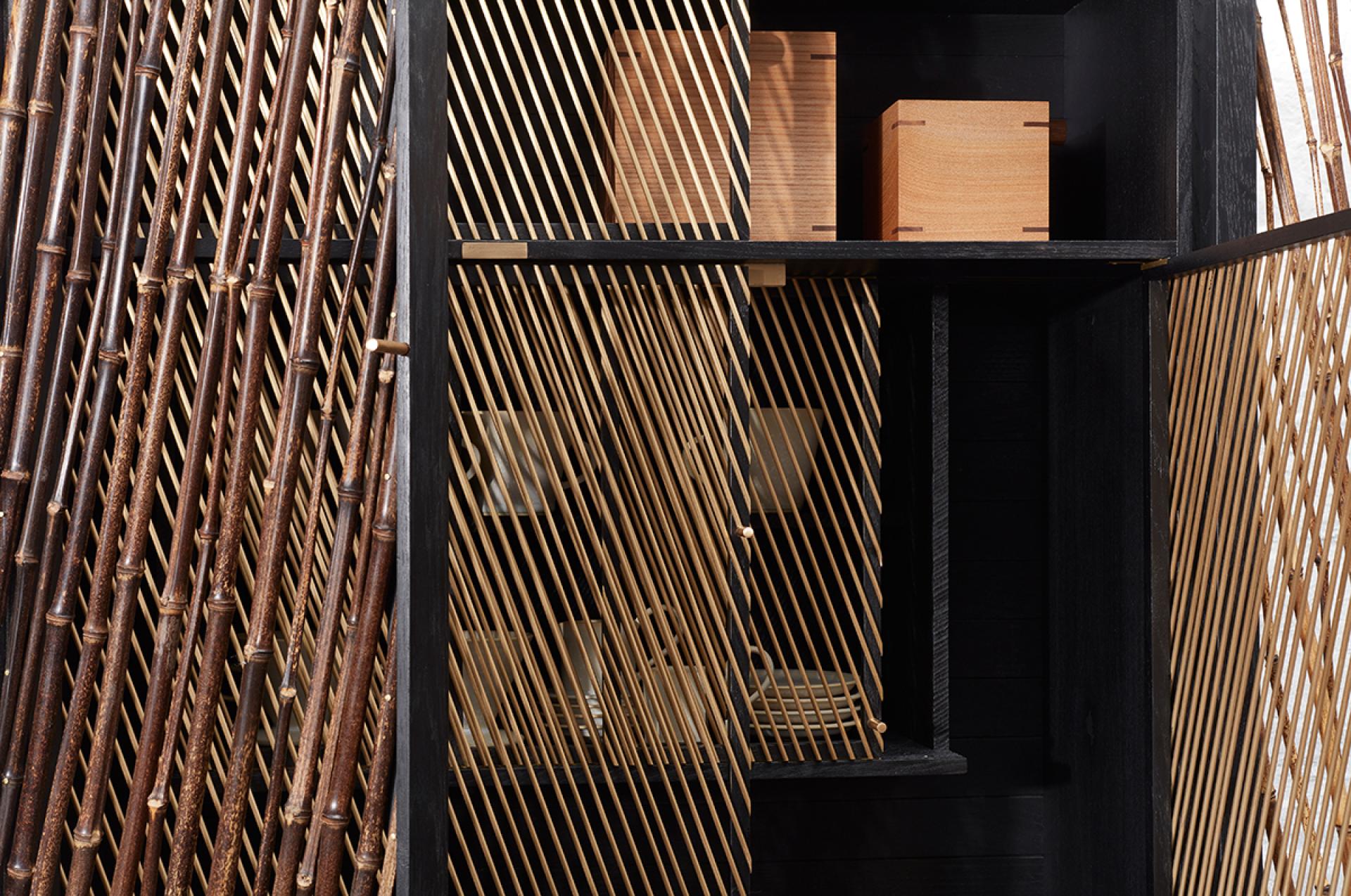 Elegant black stained drinks cabinet by Hugh Miller, showcasing bamboo detailing and wooden storage boxes, inspired by Japanese design.