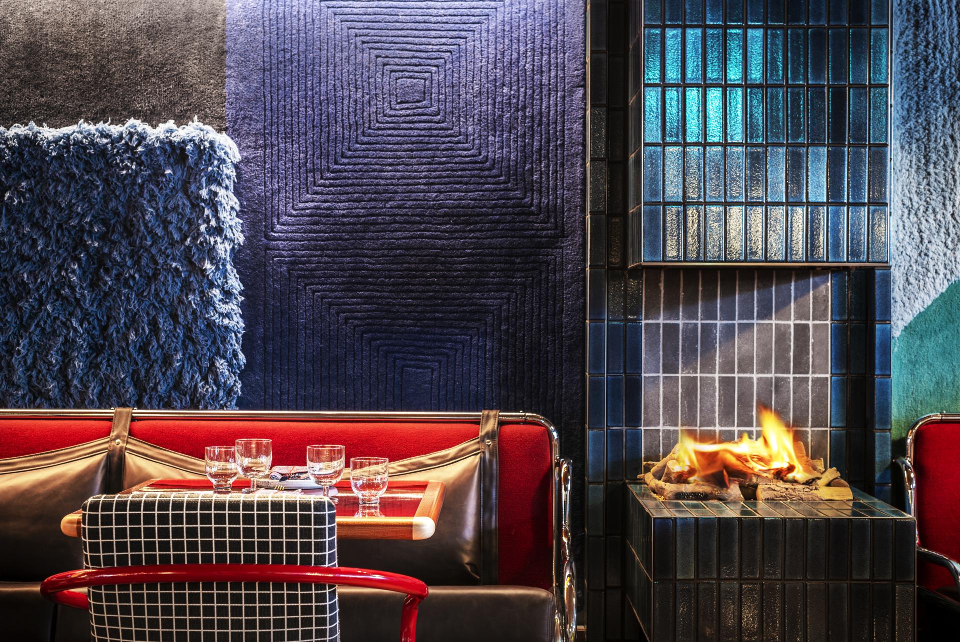 Stylish interior of The Standard, London featuring colorful textured walls, a cozy seating area, and a contemporary fireplace.